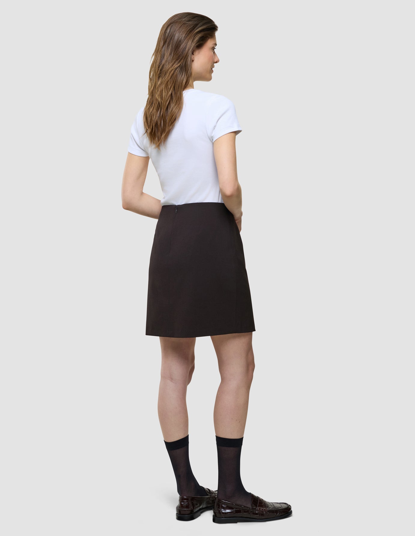 Ease Shirt i Mocha Melange og sort nederdel, kvinde set fra siden.